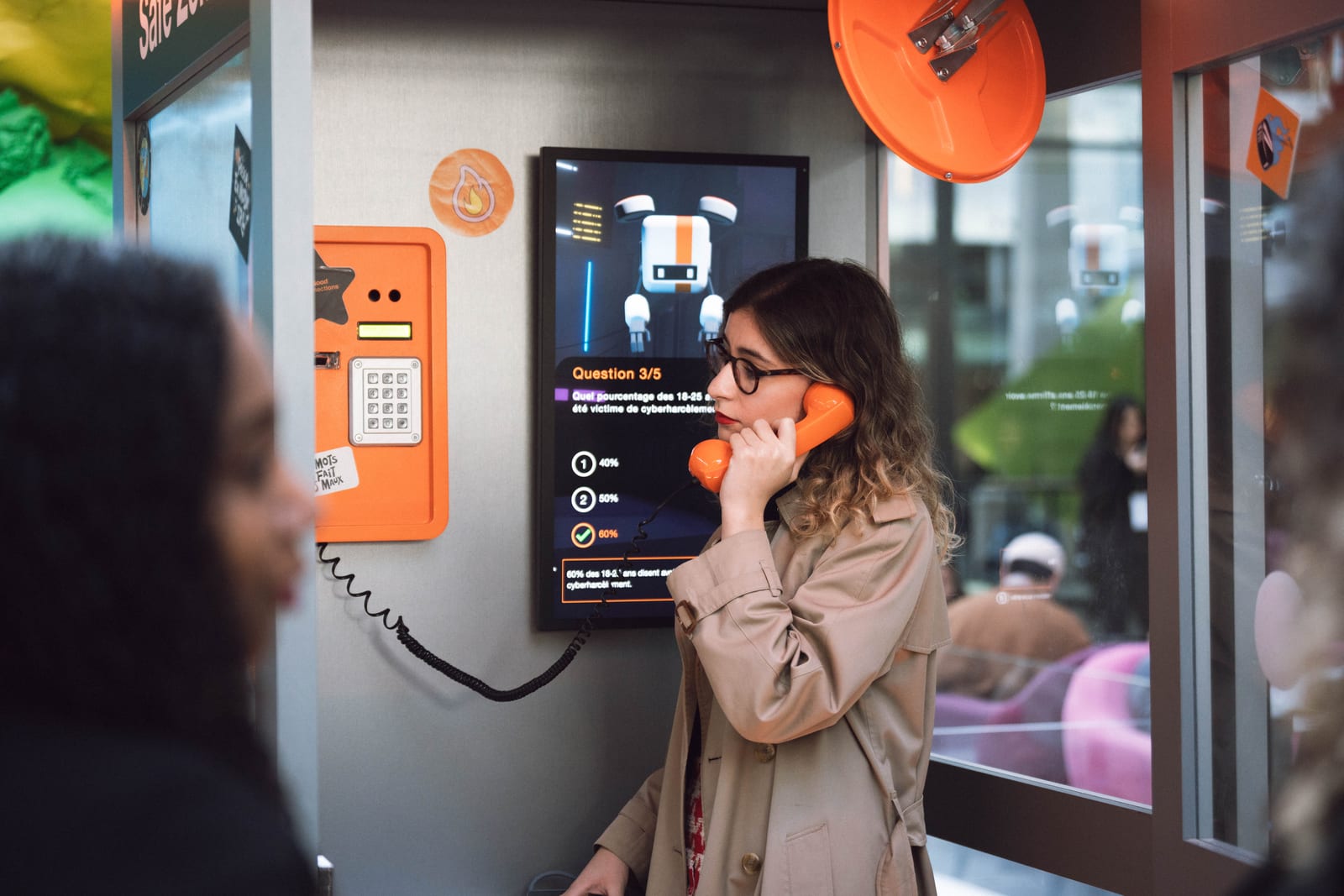 Interactive orange payphone booth - attendee playing