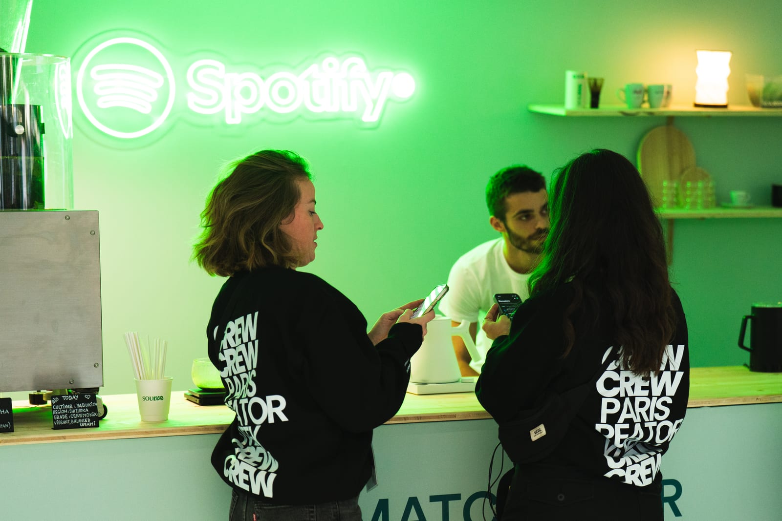 Attendees at the Spotify neon-lit green stand